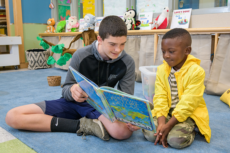 UD student helps child read a book at The College School