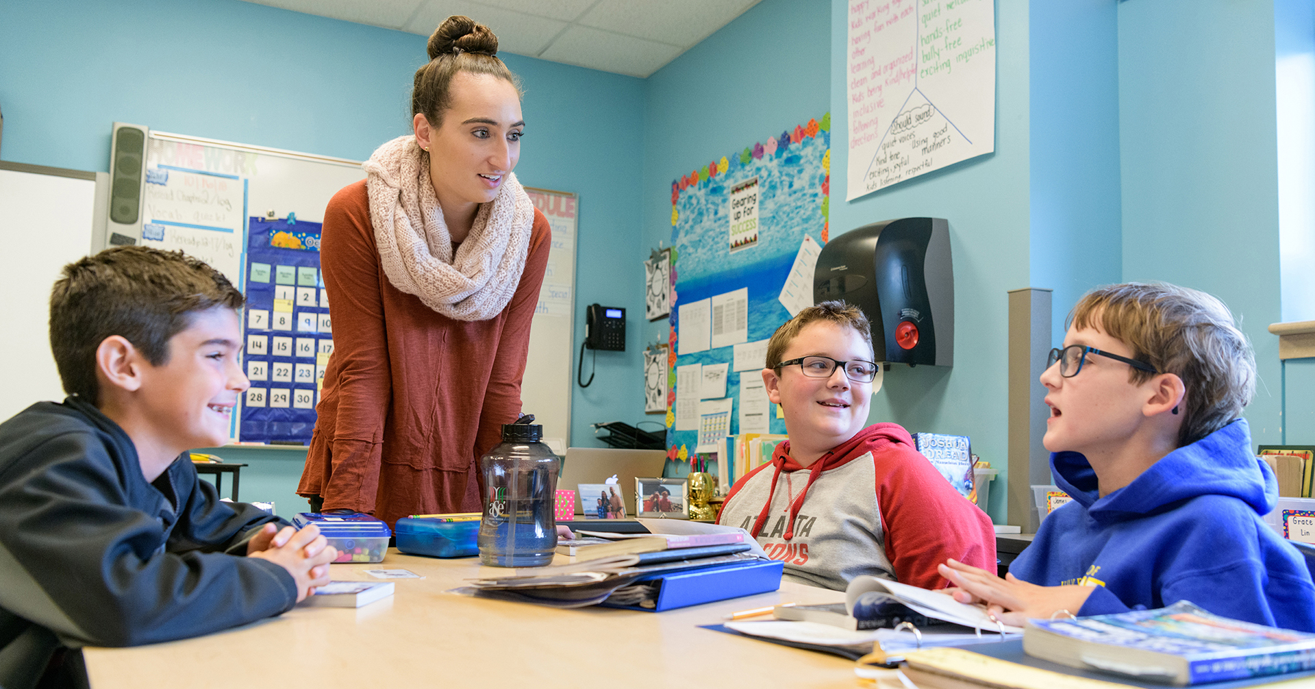 UD student talks to three excited children at The College School