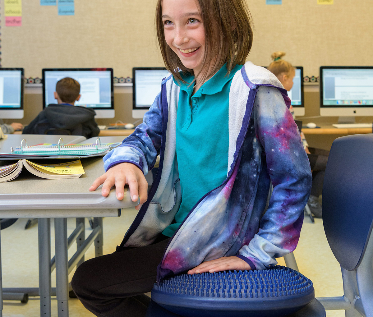 Student sits on sensory cushion at The College School