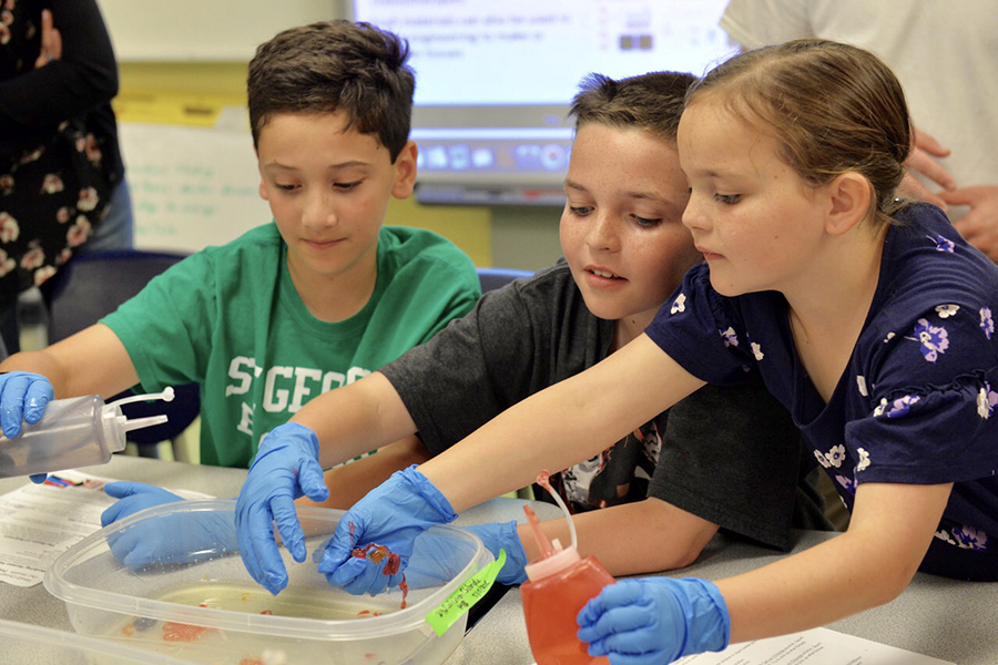 Three students conduct a science experiment at The College School